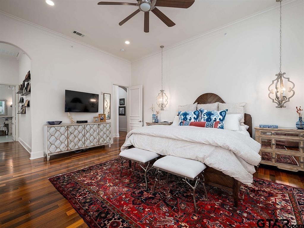 3351 Cascades Court, Unit 324 Tyler, TX 75709 - Photo 20 of 46 a spacious bedroom with a bed a flat screen tv and a chandelier