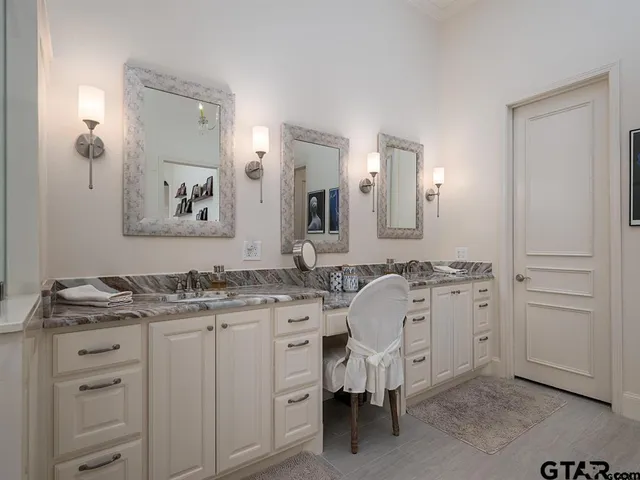 a spacious bathroom with a granite countertop sink and a mirror