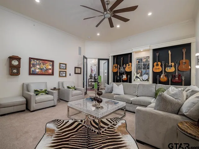 a living room with furniture and a ceiling fan