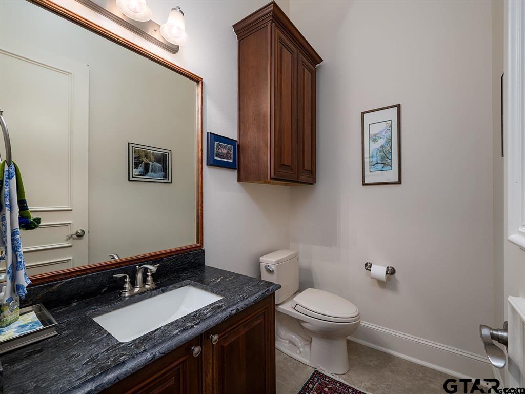 3351 Cascades Court, Unit 324 Tyler, TX 75709 - Photo 36 of 46 a bathroom with a granite countertop toilet sink and mirror