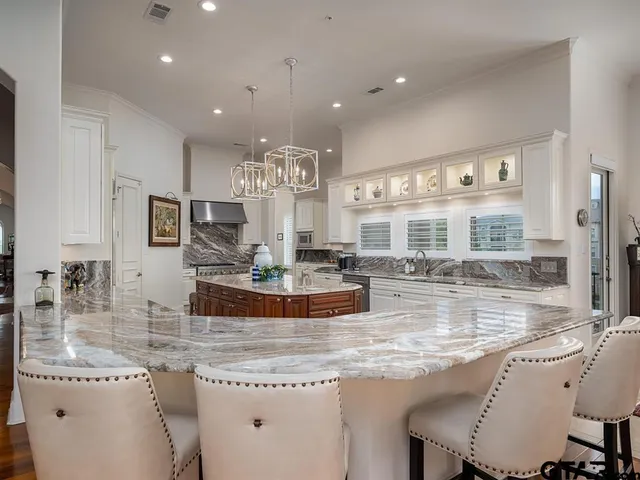 a kitchen with kitchen island granite countertop a large counter top appliances and cabinets