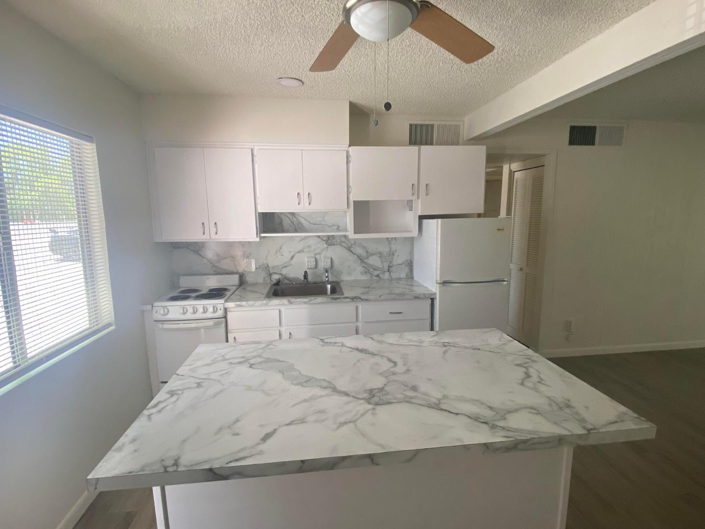 4140 East Cliffside Trail, Unit G Rimrock, AZ 86335 - Photo 9 of 25 a large white kitchen with kitchen island a stove a sink and a refrigerator