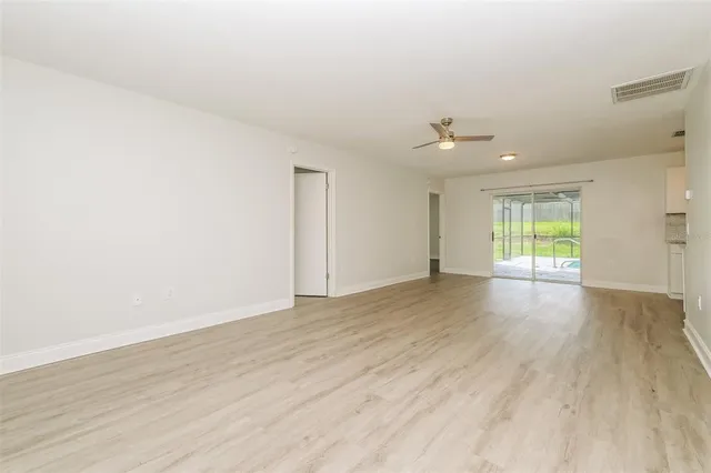 a view of a kitchen with wooden floor and a window