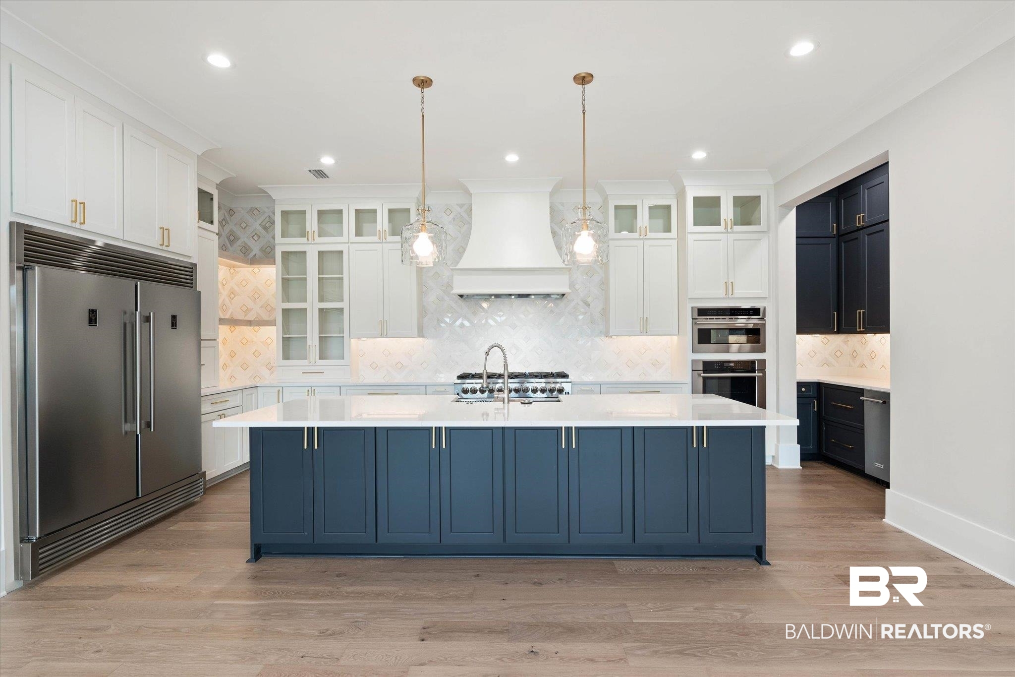 853 Inlet Circle Gulf Shores, AL 36542 - Photo 10 of 55 Kitchen featuring light countertops, an island with sink, stainless steel appliances, backsplash, and custom exhaust hood