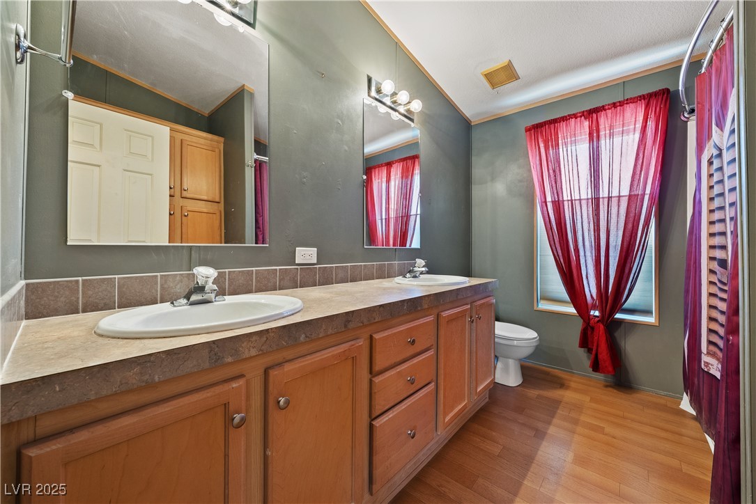 1391 East Casey Road Pahrump, NV 89048 - Photo 20 of 40 Bathroom featuring wood finished floors, toilet, and double vanity