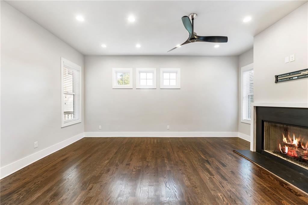 1819 Huntington Hills Lane Northwest Atlanta, GA 30309 - Photo 14 of 53 an empty room with wooden floor fireplace and windows