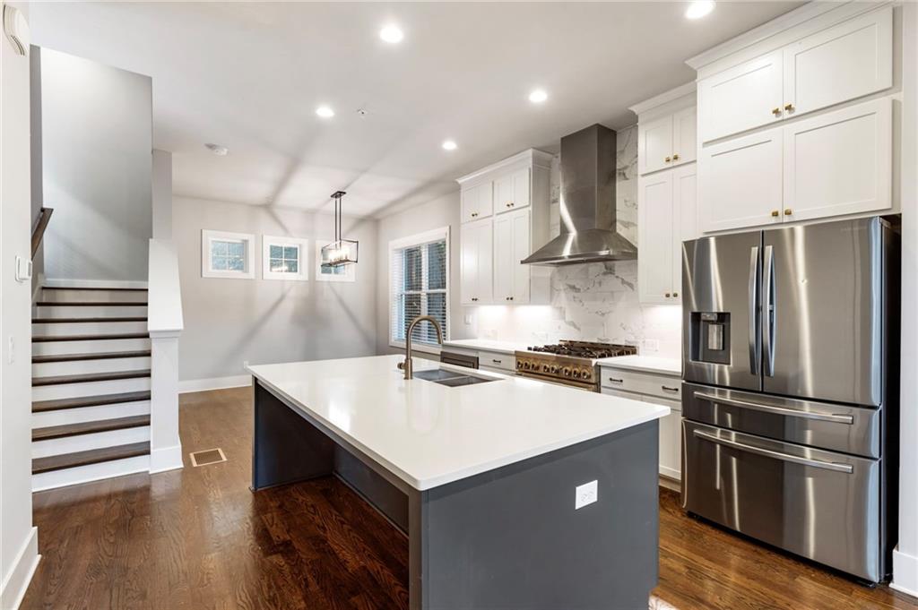 1819 Huntington Hills Lane Northwest Atlanta, GA 30309 - Photo 19 of 53 a kitchen with kitchen island white cabinets and stainless steel appliances