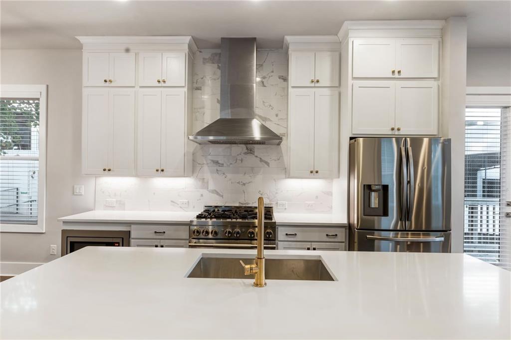 1819 Huntington Hills Lane Northwest Atlanta, GA 30309 - Photo 20 of 53 a kitchen with stainless steel appliances granite countertop a refrigerator a stove and a sink