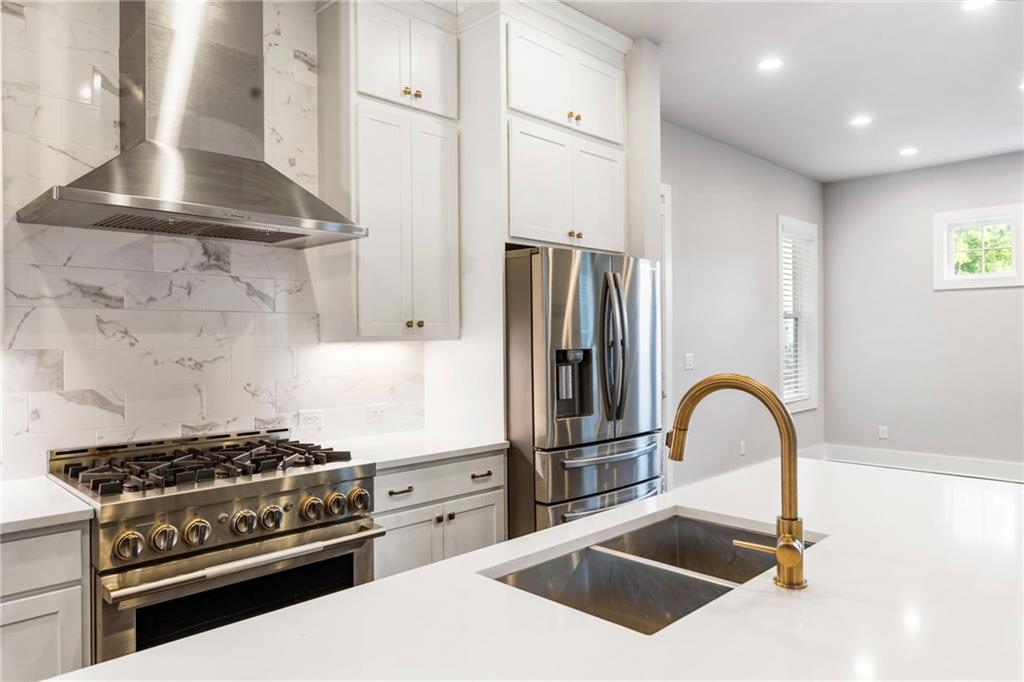 1819 Huntington Hills Lane Northwest Atlanta, GA 30309 - Photo 23 of 53 a kitchen with stainless steel appliances kitchen island a stove a sink and a refrigerator