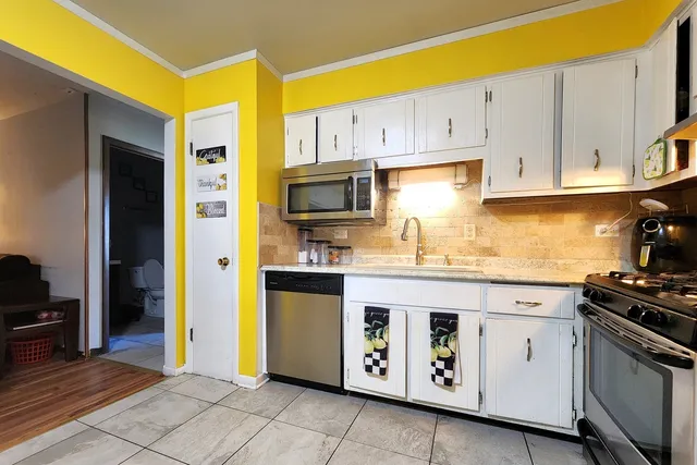 a kitchen with stainless steel appliances granite countertop a stove a sink and a refrigerator