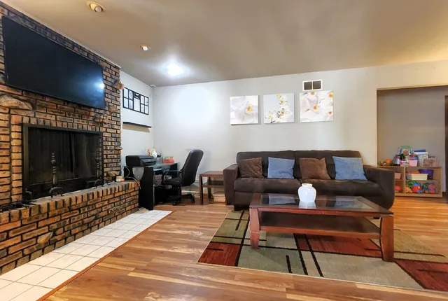 a living room with furniture a flat screen tv and a fireplace