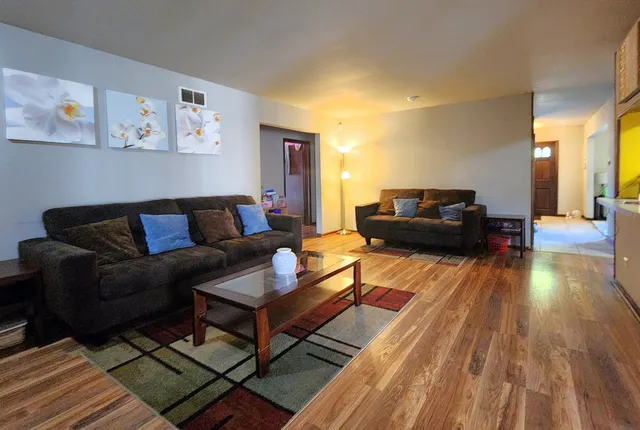 a living room with furniture and wooden floor