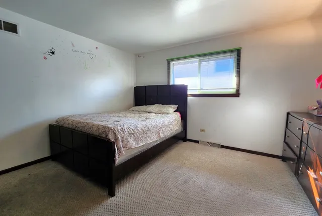a bedroom with a bed lamp and a window