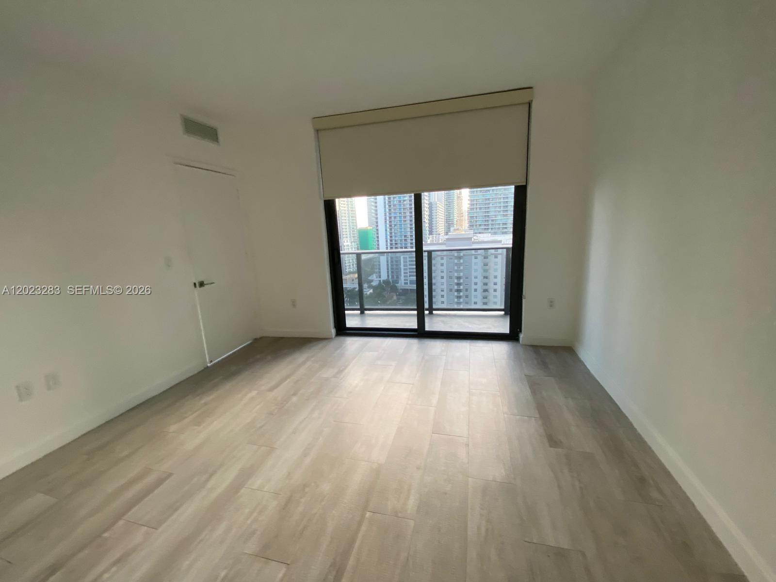55 Southwest 9th Street, Unit 1503 Miami, FL 33130 - Photo 9 of 11 wooden floor and window in an empty room