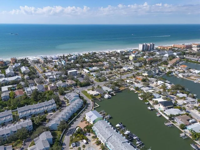 an aerial view of ocean and residential houses with outdoor space