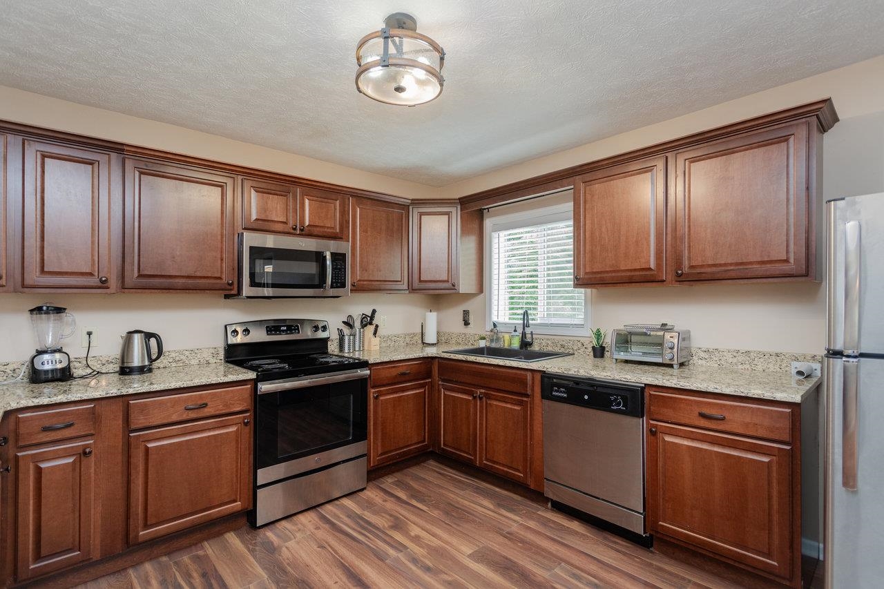 159 Park View Shenandoah, VA 22849 - Photo 15 of 70 a kitchen with stainless steel appliances granite countertop wooden cabinets a sink a stove a refrigerator with grey cabinets and wooden floor