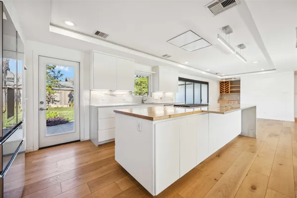 a kitchen with a dining table chairs refrigerator and cabinets