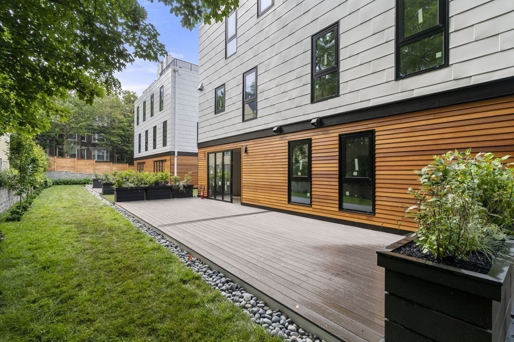 41 Stearns Road, Unit SF Brookline, MA 02446 - Photo 23 of 26 a front view of a house with a yard and potted plants