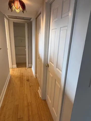 a view of a hallway with wooden floor and staircase