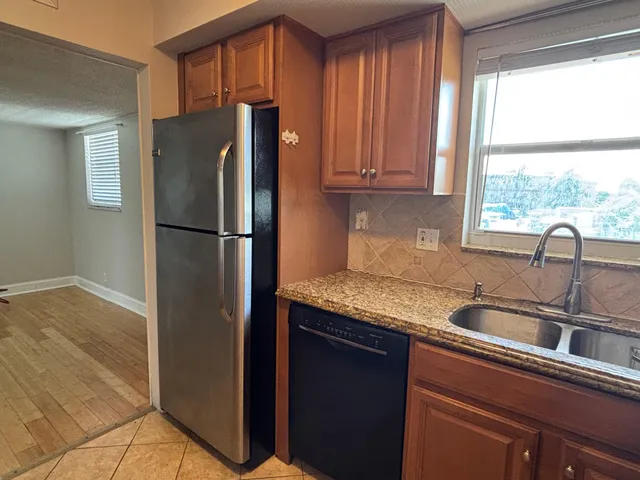 a kitchen with granite countertop a refrigerator and a sink