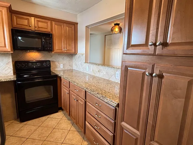 a kitchen with granite countertop a stove and a microwave