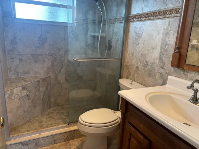 a bathroom with a sink a toilet and shower