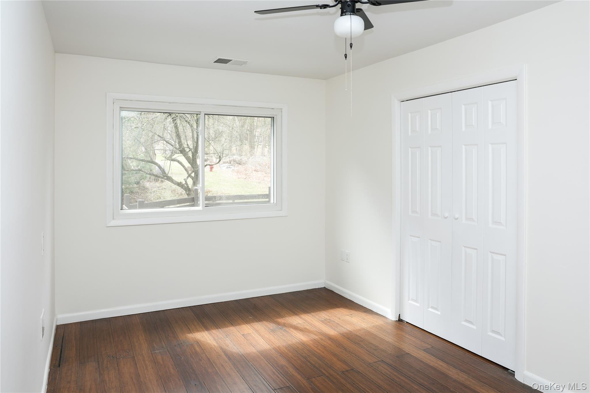 3675 Old Yorktown Road, Unit 13 Shrub Oak, NY 10588 - Photo 15 of 26 an empty room with wooden floor fan and windows