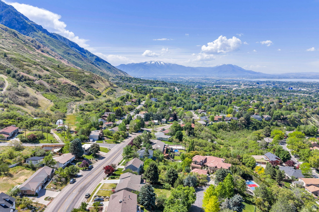 3813 North Foothill Drive Provo, UT 84604 - Photo 59 of 71 Aerial perspective showcasing a residential area nestled at the base of mountains, with a distant body of water and additional mountains on the horizon