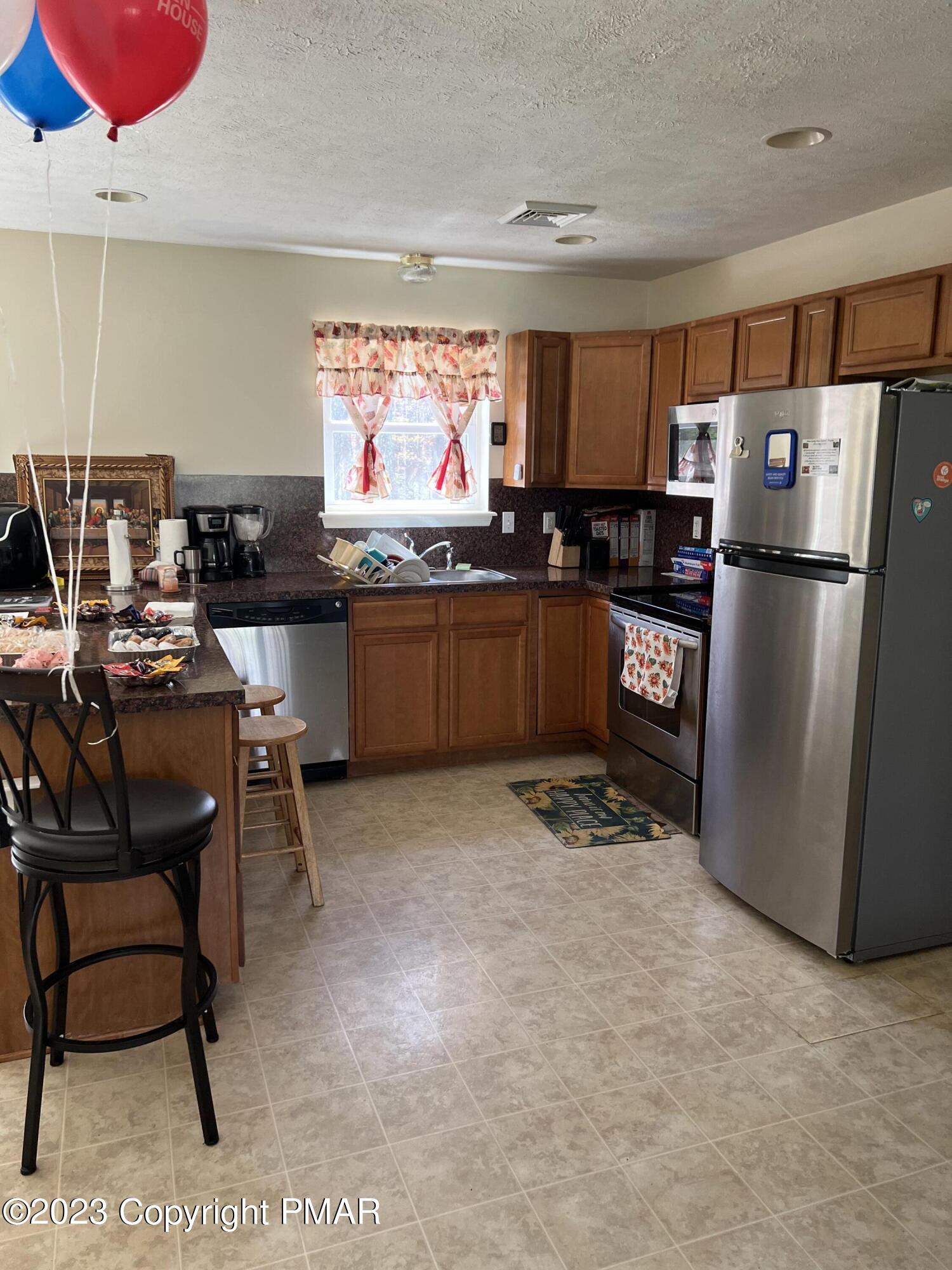 310 Coach Road Tobyhanna, PA 18466 - Photo 33 of 41 a kitchen with refrigerator and chairs