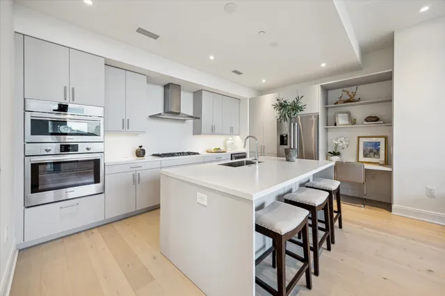 a kitchen with stainless steel appliances kitchen island a table and chairs in it