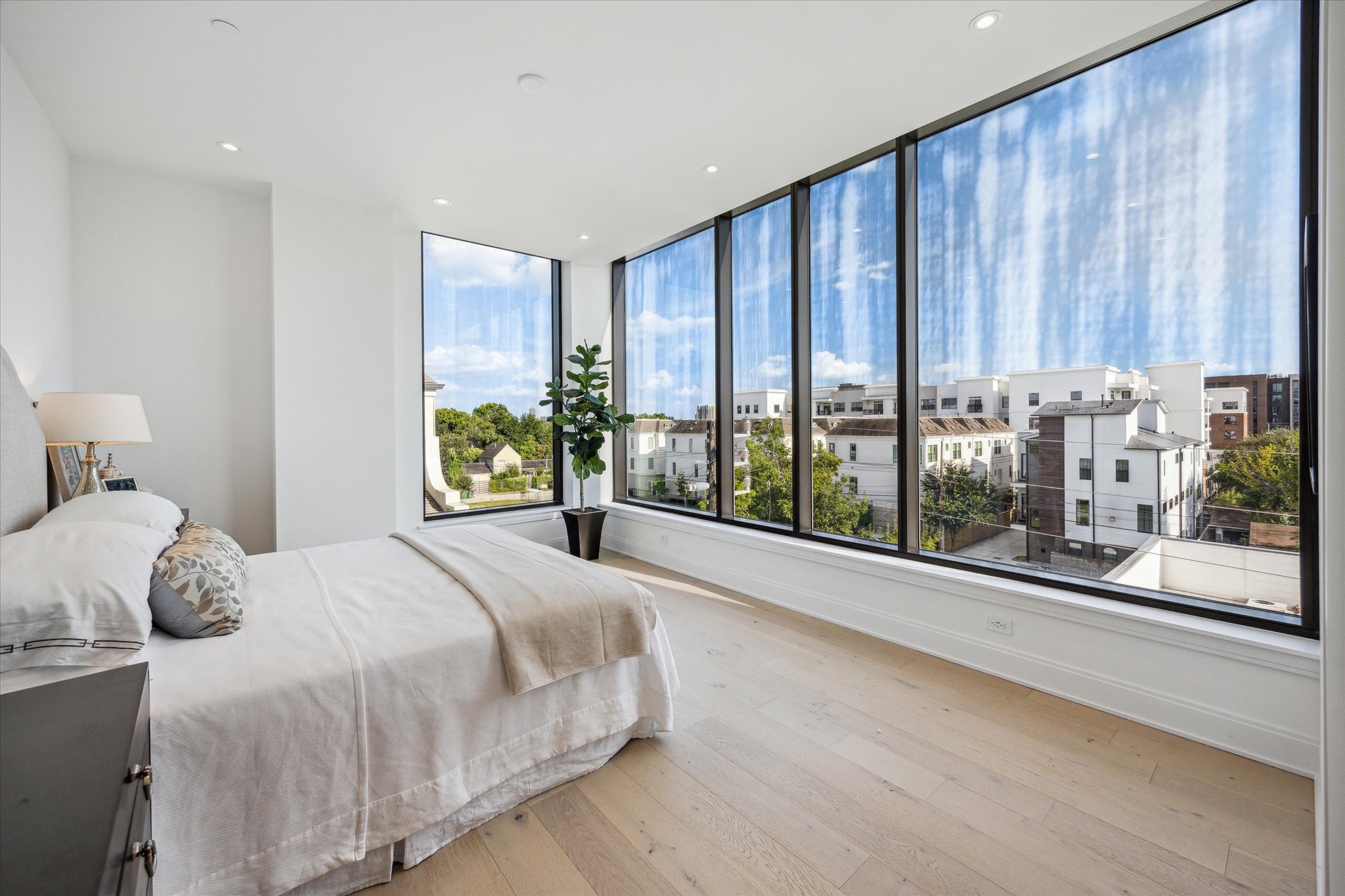 2323 West Main Street, Unit 402 Houston, TX 77098 - Photo 10 of 30 Primary bedroom with south facing windows. Beautiful wide plank wood floors, tall ceilings, and recessed lighting.
