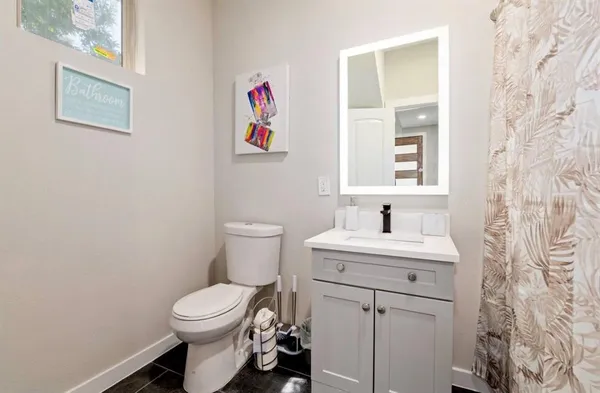 a bathroom with a toilet a sink and a window