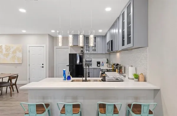 a kitchen with stainless steel appliances granite countertop a sink a stove and a refrigerator