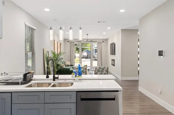 a view of a kitchen with kitchen island a sink stainless steel appliances and cabinets