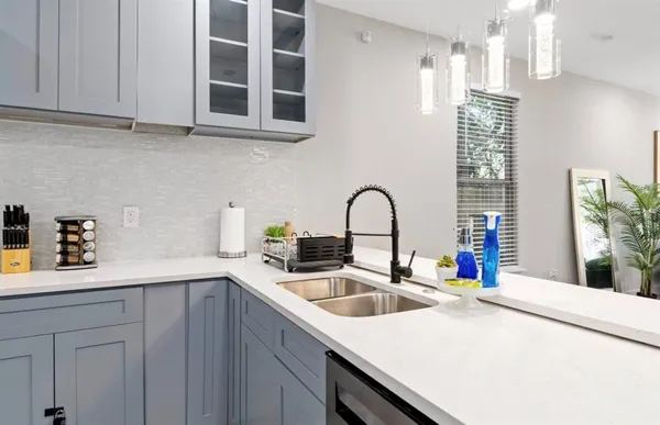 a kitchen with stainless steel appliances a sink a stove and a wooden cabinets