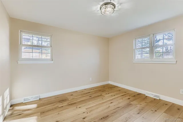 a view of a room with wooden floor and window