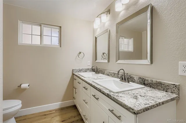 a bathroom with a granite countertop sink and a mirror