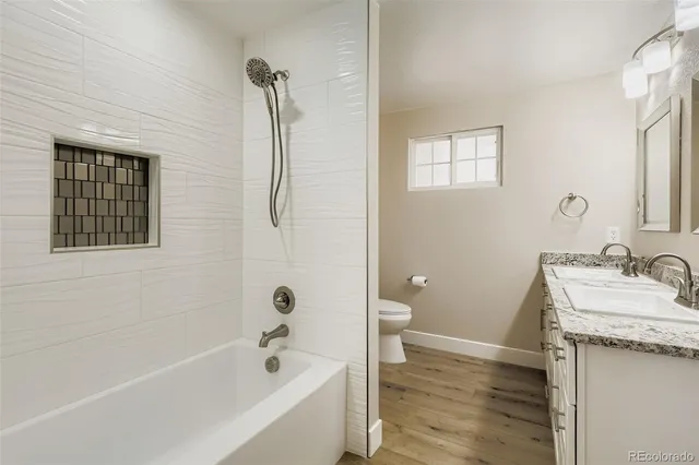 a bathroom with a granite countertop sink toilet and shower