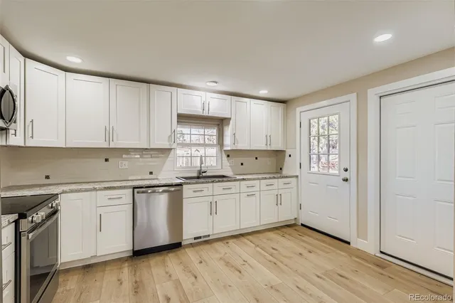 a kitchen with granite countertop white cabinets and white appliances