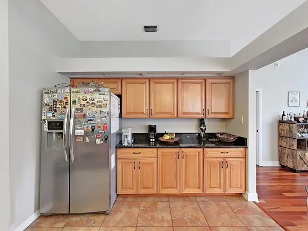 a kitchen with granite countertop a refrigerator and a sink