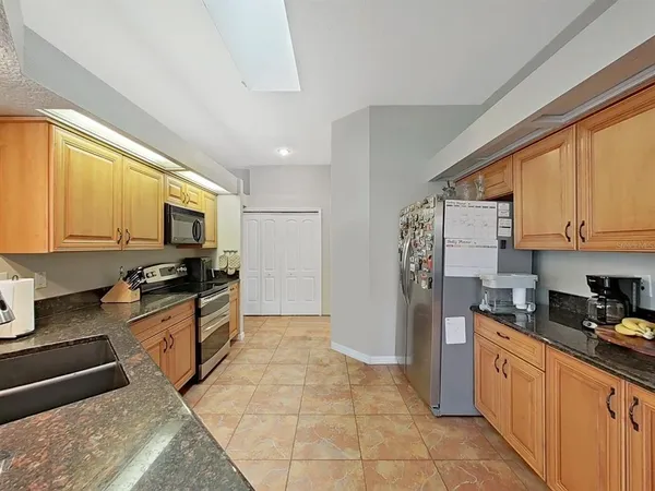 a kitchen with stainless steel appliances granite countertop a stove a sink and a refrigerator