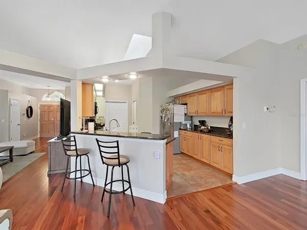 a kitchen with stainless steel appliances a dining table chairs and wooden floor