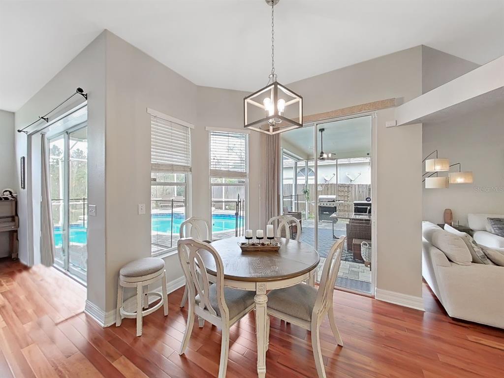 9630 Fox Hearst Road Tampa, FL 33647 - Photo 20 of 47 a view of a dining room with furniture wooden floor and chandelier