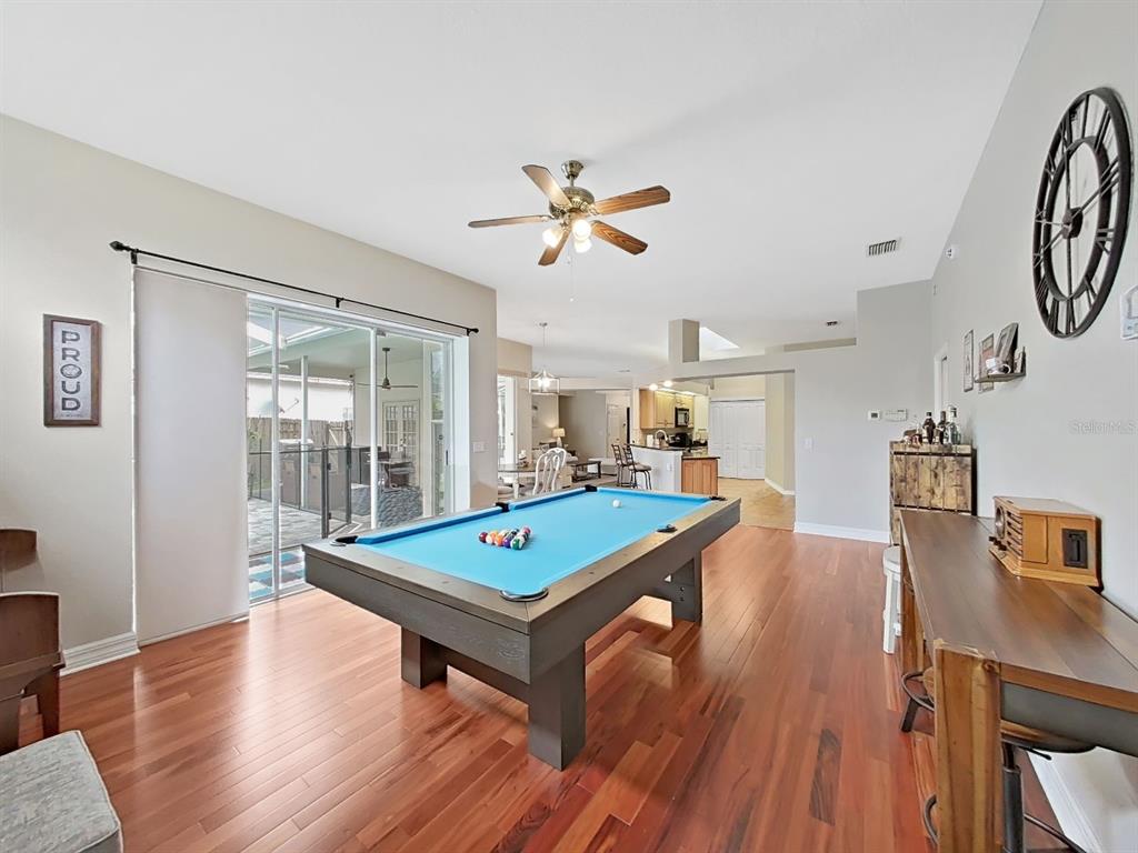 9630 Fox Hearst Road Tampa, FL 33647 - Photo 23 of 47 a room with wooden floor pool table and windows
