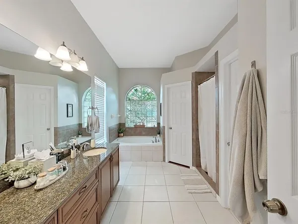 a large white kitchen with a large window and stainless steel appliances