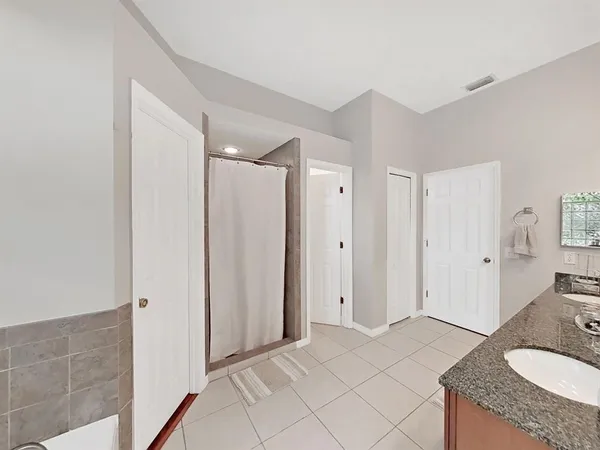 a spacious bathroom with a granite countertop sink and a mirror