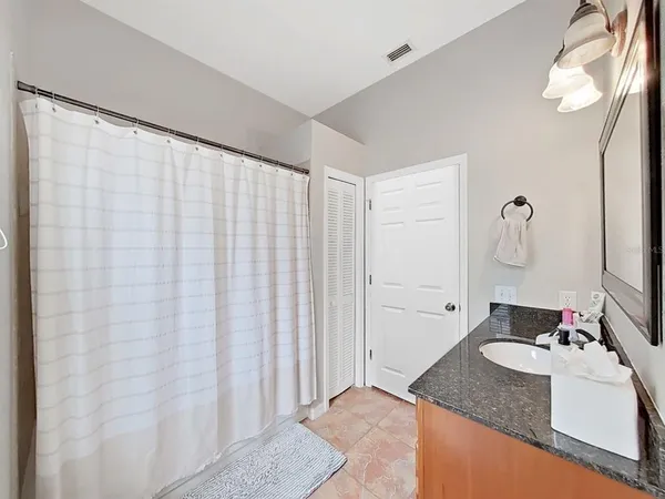 a bathroom with a granite countertop sink and a mirror