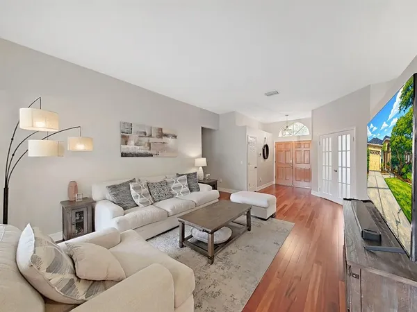 a living room with furniture and a wooden floor