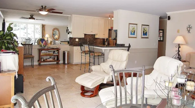 a living room with furniture a flat screen tv and a dining table
