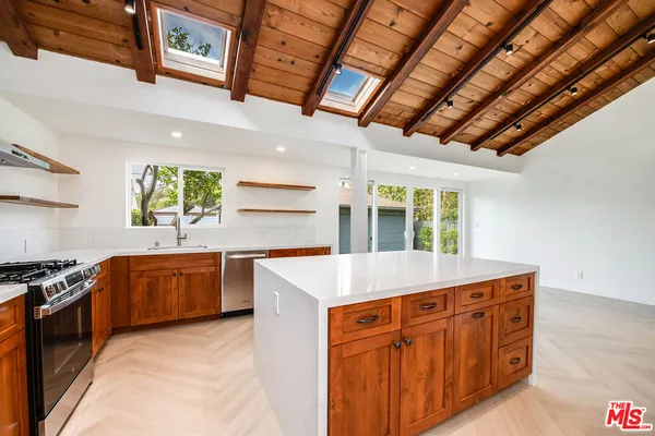 a kitchen with granite countertop a sink a counter top space and stainless steel appliances